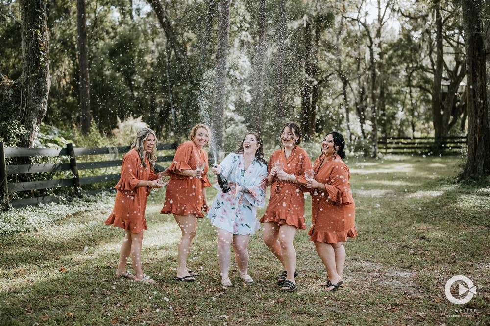 Champagne pop bridesmaids and bride outdoor photo at The Edison Barn in Tampa Bay. 